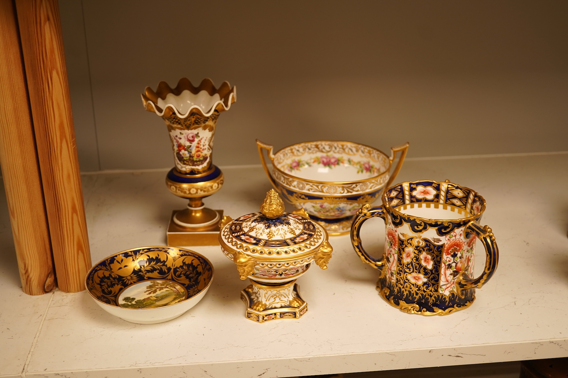A collection of Royal Crown Derby, to include a two handled bowl, a fluted pedestal vase, saucer with landscape central cartouche etc (5). Vase 19cm high.